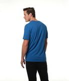 Male model body turned away from camera looking back over shoulder wearing our "azure" blue t-shirt