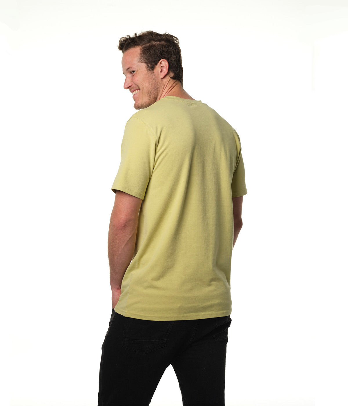 Male model body turned away from camera smiling back over shoulder wearing our "light moss" green t-shirt