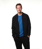 Male model grinning wearing black bomber jacket over our "azure" blue t-shirt