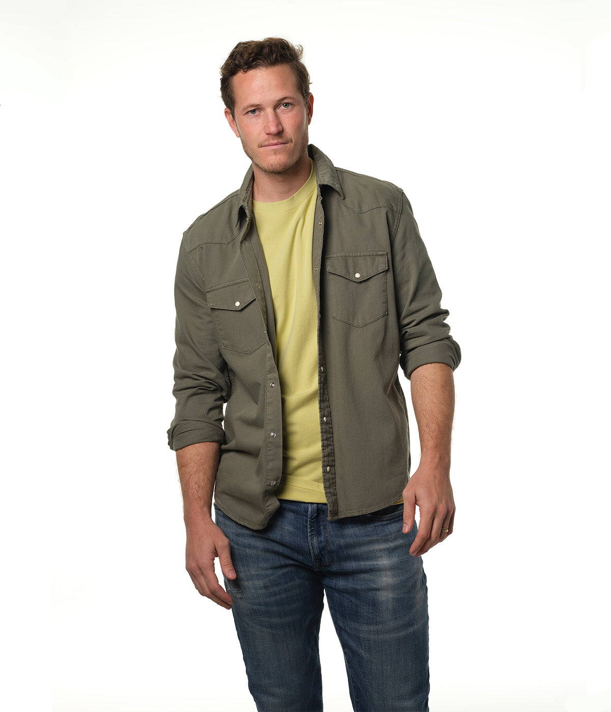 Male model wearing an olive drab denim shirt over our "light moss" green t-shirt